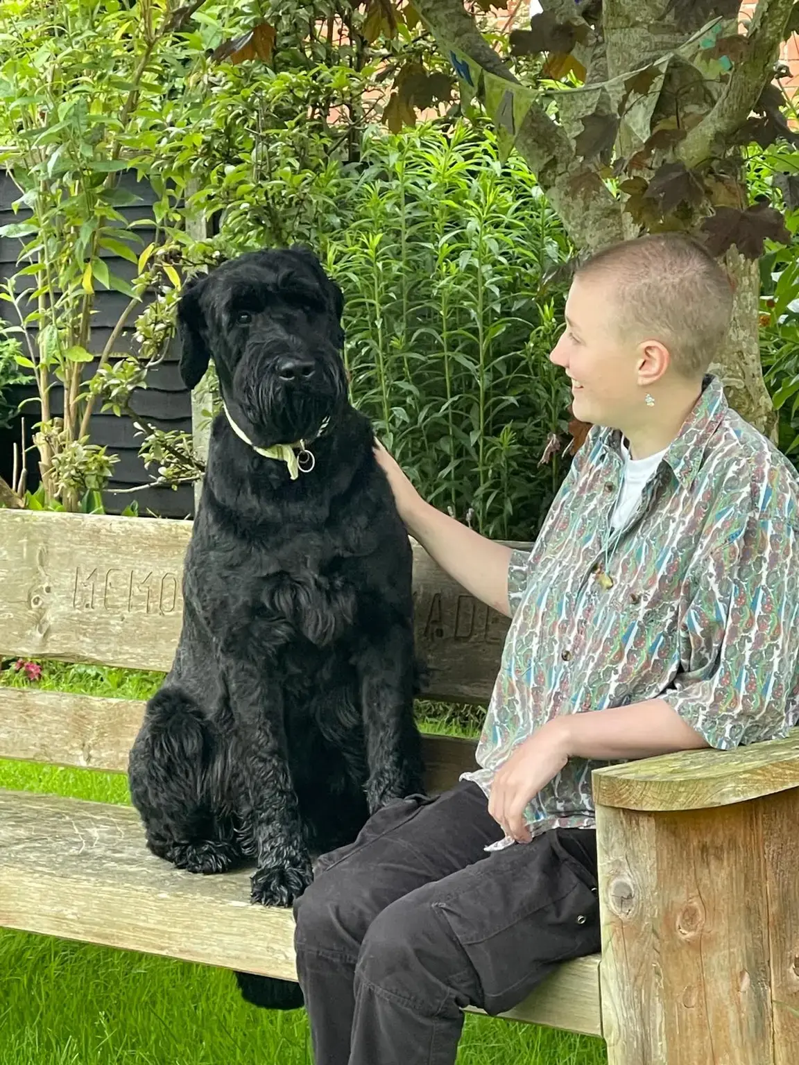 Dawn sitting calmly beside Bruce, a large black dog